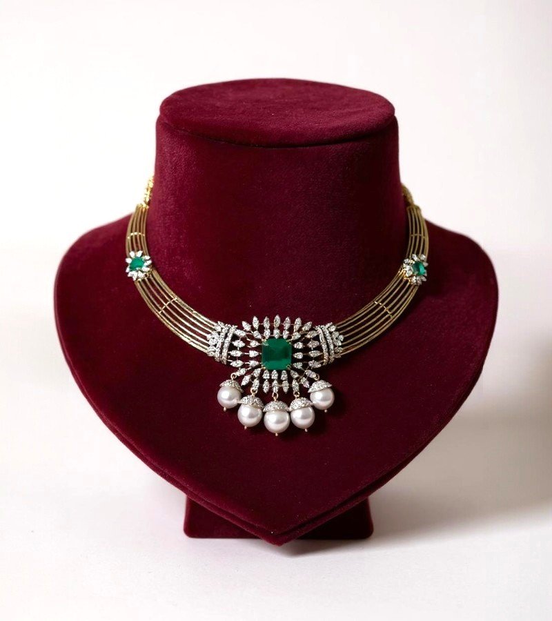 Diamond necklace featuring a central emerald and pearl drops